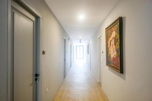 an empty hallway with a painting on the wall and a hallway sidx sidx at Urbanview Hotel JJ Bukitsari Semarang in Jatingaleh