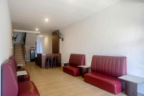 a waiting room with two red chairs and a table at Urbanview Hotel JJ Bukitsari Semarang in Jatingaleh