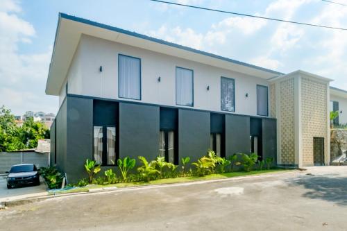 a white and black building with a car parked in front at Urbanview Hotel JJ Bukitsari Semarang in Jatingaleh