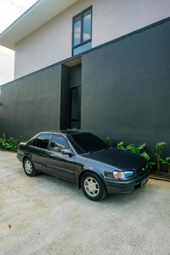 a black car parked in front of a building at Urbanview Hotel JJ Bukitsari Semarang in Jatingaleh