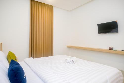 a hotel room with a bed with a towel on it at Urbanview Hotel JJ Bukitsari Semarang in Jatingaleh
