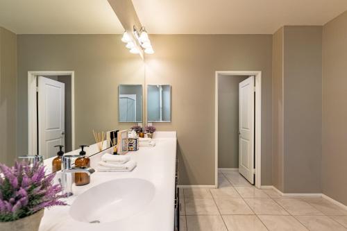 a bathroom with a sink and a mirror at Luxe Indio Stay w Pool Tiki Bar Fire Pit Near Coachella Longfellow in Indio