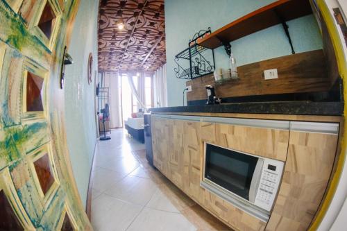 a kitchen with a microwave on a counter at Atlantic Pousada in São Sebastião