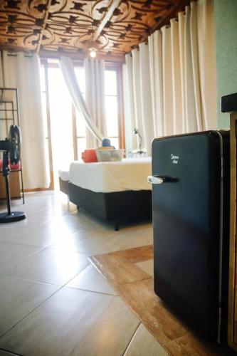 a bedroom with a bed and a refrigerator in it at Atlantic Pousada in São Sebastião