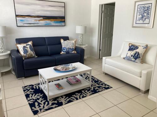 a living room with a blue couch and a white chair at Gorgeous Beachy Chic Condo in Key Biscayne in Miami