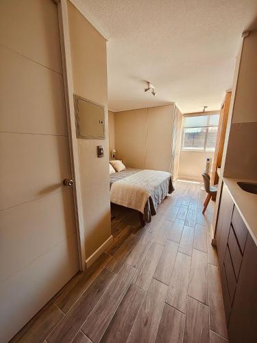 a bedroom with a bed and a large window at Confort de Ñuñoa in Santiago
