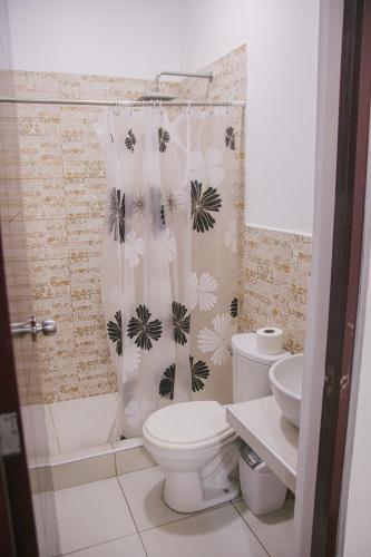 a bathroom with a toilet and a shower curtain at Charm & Confort - Tarapoto - Peru in Tarapoto