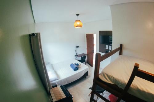 a small room with a bed and a mirror at Atlantic Pousada in São Sebastião
