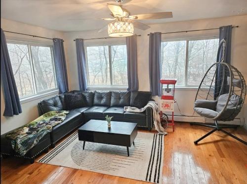 a living room with a black couch and a table at Deer Chalet in the heart of Pocono in Tobyhanna