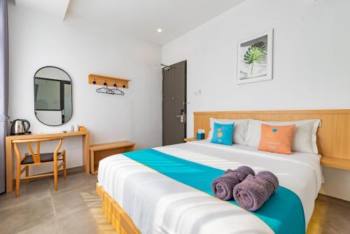 a bedroom with a large bed and a desk at Sans Hotel Bobosini Malang by RedDoorz in Malang