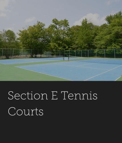 two people playing tennis on a tennis court at Deer Chalet in the heart of Pocono in Tobyhanna