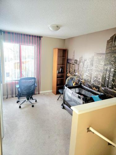 a room with a bed and a chair in it at Cozy Luxury House in Edmonton