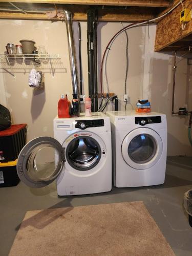 a washer and a washing machine in a garage at Cozy Luxury House in Edmonton