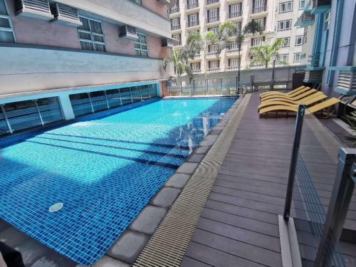 a large swimming pool in a building with chairs at A&G Condotel at 101newport Near NAIA T3 in Manila
