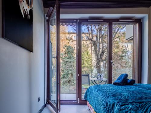 une chambre avec un lit et une grande fenêtre en verre dans l'établissement Loft vistula old town apartament free parking, à Cracovie