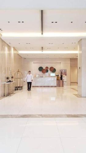 a man standing in a large room with a lobby at A&G Condotel at 101newport Near NAIA T3 in Manila