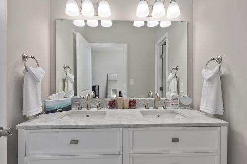 a bathroom with two sinks and a large mirror at Cozy & Modern Home Close to Uptown & Airport in Charlotte
