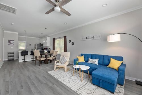 a living room with a blue couch and a dining room at Cozy & Modern Home Close to Uptown & Airport in Charlotte