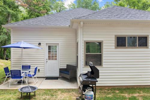 a house with a grill and chairs and an umbrella at Cozy & Modern Home Close to Uptown & Airport in Charlotte