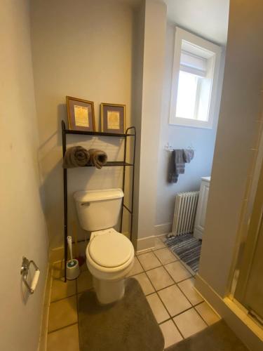 a bathroom with a white toilet and a window at Cozy 1 bedroom apartment in Allentown