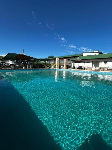 a pool of blue water in front of a building at IRUPÉ APART HOTEL in Federación