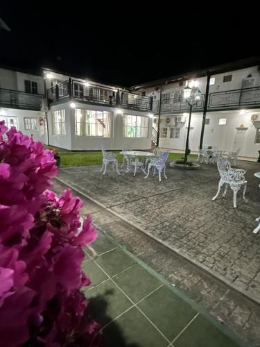 a group of white chairs in a courtyard at night at IRUPÉ APART HOTEL in Federación
