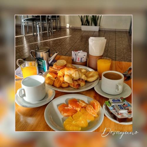 a table with plates of food and cups of coffee at IRUPÉ APART HOTEL in Federación