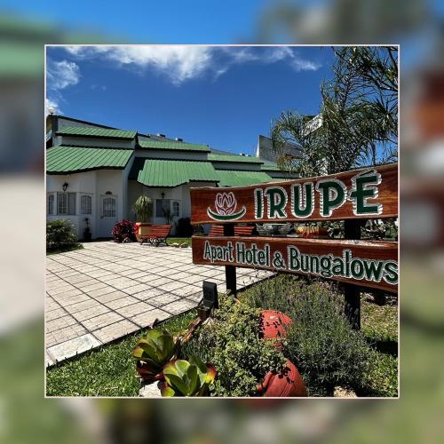 a sign in front of a hotel and a building at IRUPÉ APART HOTEL in Federación