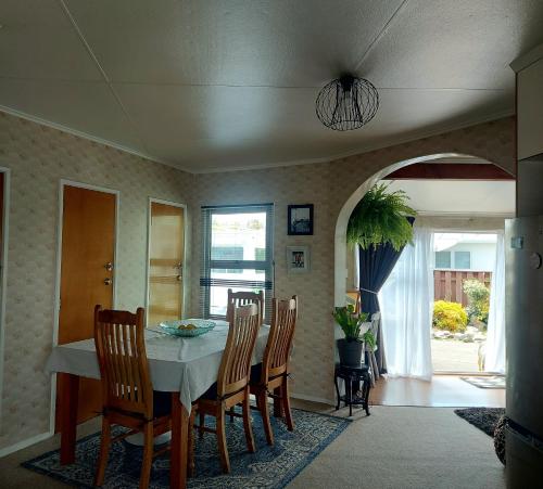 a dining room with a table and chairs at Three Doors Whole 3bdr Home Central Motueka in Motueka
