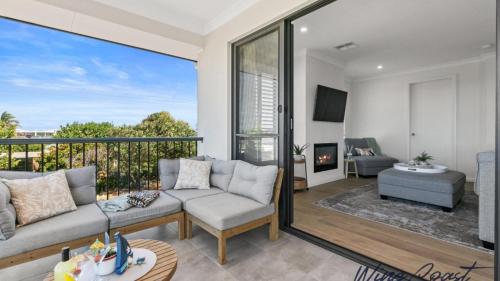 a living room with a couch and a balcony at Mid Coast Surf & Vines By Wine Coast Holidays in Port Noarlunga South