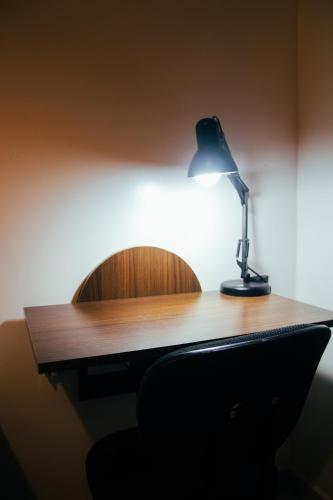 a desk with a lamp sitting on top of it at Atlantic Pousada in São Sebastião