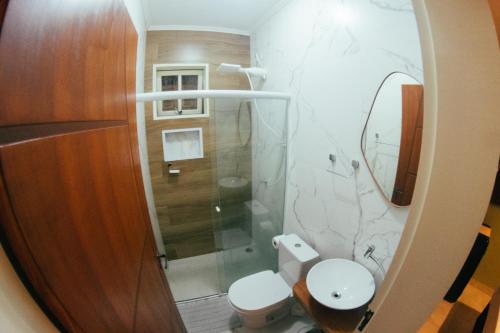 a small bathroom with a toilet and a shower at Atlantic Pousada in São Sebastião