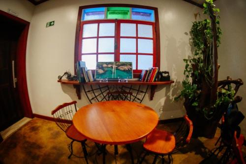 a table and chairs in a room with a window at Atlantic Pousada in São Sebastião