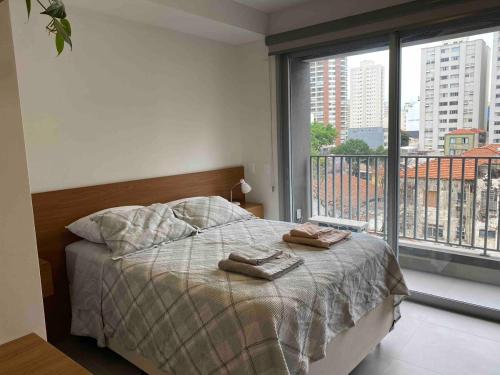 um quarto com uma cama com duas toalhas em Studio em Pinheiros a uma quadra da Faria Lima em São Paulo