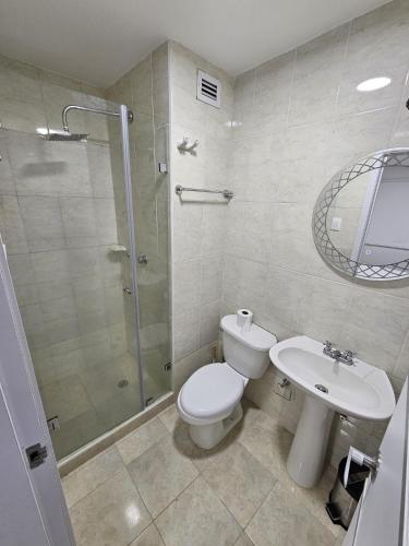 a bathroom with a toilet and a shower and a sink at Lujoso departamento en Playa el Angel in Pampatar
