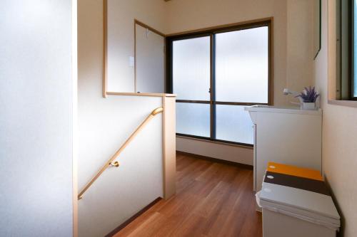 Zimmer mit einer Treppe und einem großen Fenster in der Unterkunft 和風庵Wafuna 7min walk to Teradacho Loop Line Station in Osaka