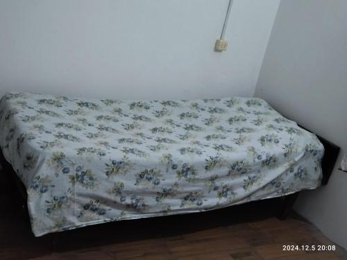 a bed in a corner of a room with a blanket at Casa ilusión in Artilleros