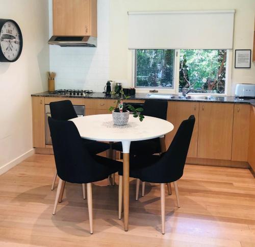 una cucina con tavolo e sedie bianchi di Daylesford Lake Villa1 Lake Frontage pet friendly a Daylesford
