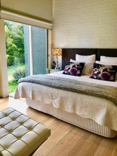 a bedroom with a large bed with a large window at Daylesford Lake Villa1 Lake Frontage pet friendly in Daylesford