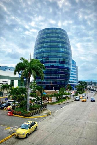 a yellow car driving down a street in front of a building at Ecuabook Wyndham Garden Torre Sol 907 in Guayaquil