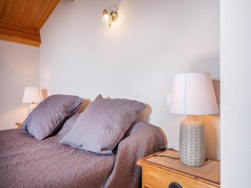 un lit avec deux oreillers et une lampe sur une table dans l'établissement Stone House in Ardèche with Private Pool, à Rocher