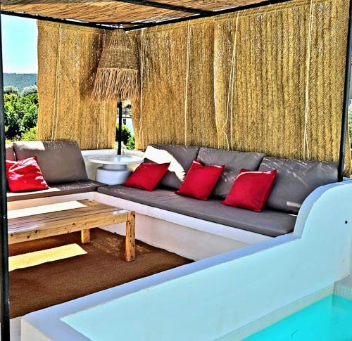 a couch with red pillows sitting in a room at Refúgio do Bode 17 in Levegada