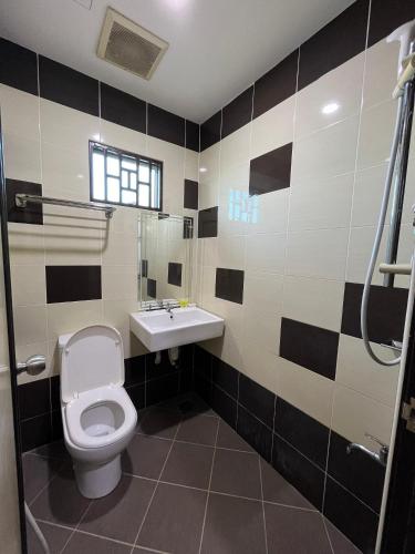 a bathroom with a toilet and a sink at Sera Sentosa Inn in Kampong Perin