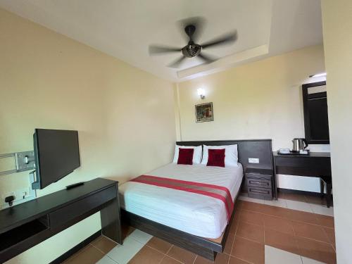 a bedroom with a bed and a ceiling fan at Sera Sentosa Inn in Kampong Perin