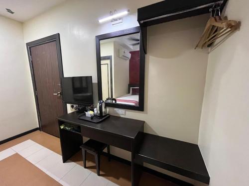 a bathroom with a black desk and a mirror at Sera Sentosa Inn in Kampong Perin