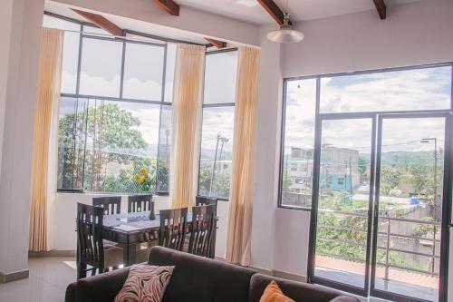 ein Wohnzimmer mit einer Couch und einem Tisch und Fenstern in der Unterkunft Charm & Confort - Tarapoto - Peru in Tarapoto