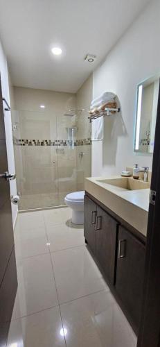 a bathroom with a shower and a sink and a toilet at Departamento Torre Iberika Cercas Del Malecon in Mazatlán