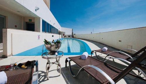 a swimming pool with a table and chairs on a building at Flat 606 GO Inn Hotel in Brasilia