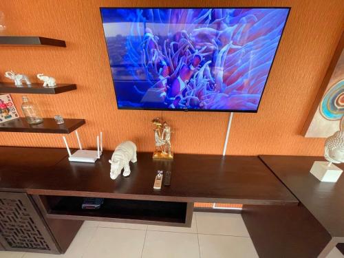 a living room with a tv on a wall at Ecuabook OmniHospital Torre Sol 702 in Guayaquil