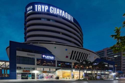 a large building with a sign on top of it at Ecuabook OmniHospital Torre Sol 702 in Guayaquil